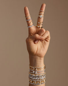 a person making the peace sign with their fingers and bracelets on each hand,