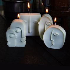 three candles with faces on them sitting next to each other