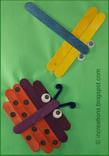 two popsicle puppets made to look like an insect with eyes and nose on green background