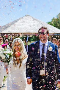 a newly married couple walking through confetti