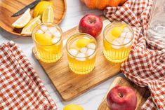 two glasses of lemonade and apples on a cutting board