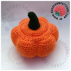 an orange knitted pumpkin sitting on top of a white table