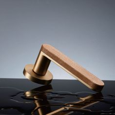 a close up of a metal object on a surface with water and light reflecting off it