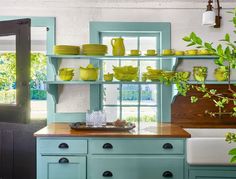 a kitchen with blue cabinets and green dishes