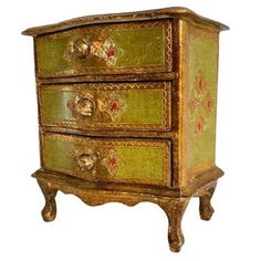 a green and gold painted chest of drawers