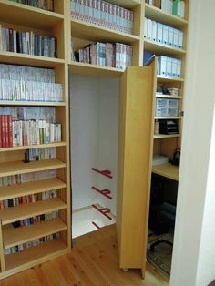 an open bookcase with many books on it in a room filled with wooden floors