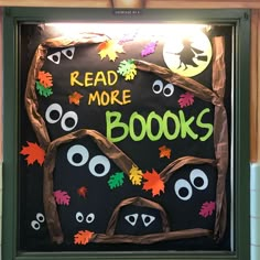 a bulletin board that reads read more books and decorated with fake leaves, googly eyes and bats