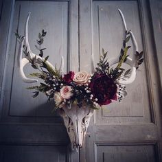 the antlers are adorned with flowers and greenery