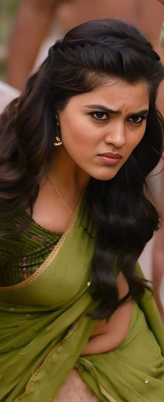 a woman in a green sari posing for the camera