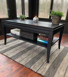 a coffee table sitting on top of a hard wood floor next to a large window