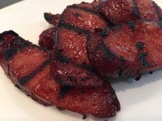 two pieces of meat sitting on top of a white plate