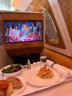 a tray with food on it and a tv in the back ground next to it