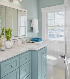 a bathroom with blue cabinets and white fixtures