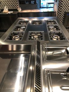 an industrial kitchen with stainless steel appliances and checkered backsplash