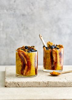 two jars filled with food sitting on top of a white counter next to each other