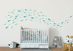 a baby's room with a crib and fish wall decals