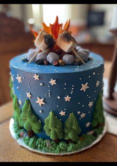 there is a blue cake with stars and trees on it