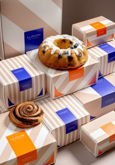 several boxes stacked on top of each other with pastries in them