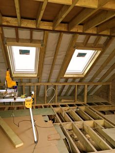 an attic with two skylights and wooden beams