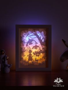 an illuminated shadow box with the silhouette of two people and a horse