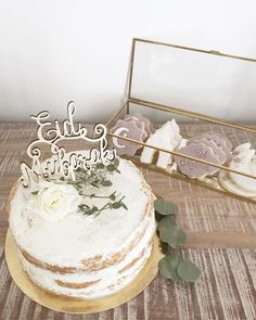 there is a cake on the table with some cookies in front of it and a mirror behind it