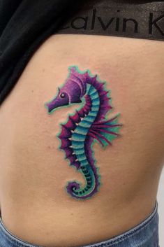 a colorful seahorse tattoo on the back of a woman's stomach