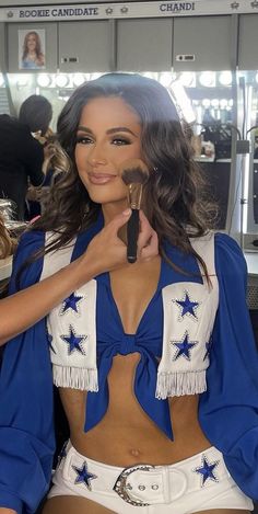 a woman in a blue and white outfit holding a brush