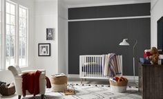 a baby's room with grey walls and white furniture