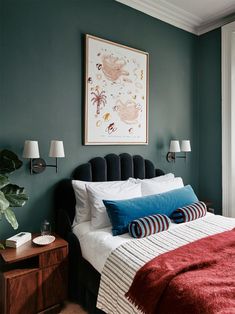 a bedroom with green walls and a red blanket on the bed, along with two lamps