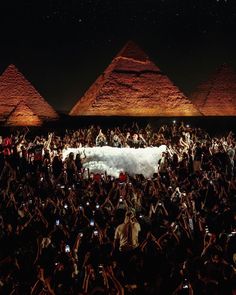 a group of people taking pictures with their cell phones in front of the pyramids