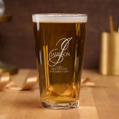 a beer glass sitting on top of a wooden table