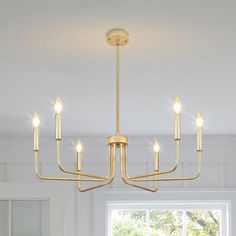 a chandelier hanging from the ceiling in a room with white walls and windows