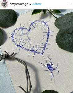 a heart drawn on top of a piece of paper next to some leaves and twigs