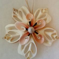 an ornament is hanging on the wall, decorated with pink and white flowers