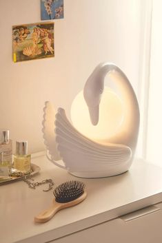 a white swan sculpture sitting on top of a counter next to a brush and bottle