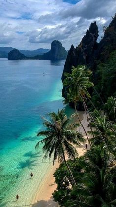 the beach is surrounded by palm trees and blue water