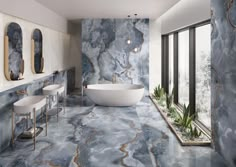 a bathroom with marble walls and flooring next to two sinks in front of a bathtub