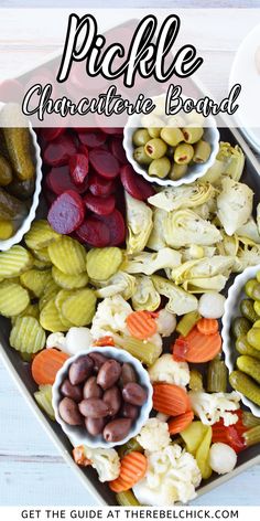 a heart shaped platter filled with pickles, olives, and other vegetables