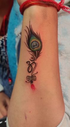 a woman's arm with a tattoo on it that has a peacock and the word love written in cursive writing