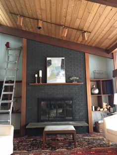 a living room with a fire place and ladder