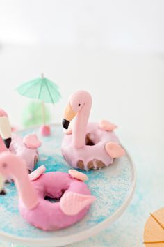 pink flamingos and donuts on a plate with an umbrella