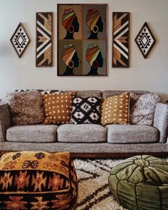 a living room filled with furniture and paintings on the wall above it's couch