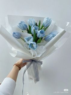 a bouquet of blue tulips wrapped in white paper