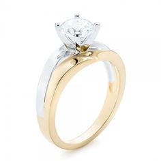 a yellow and white gold engagement ring with a single diamond on the side, set in two tone gold