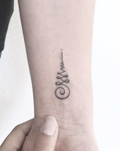 a woman's wrist with a small tattoo on the left side of her arm