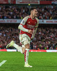 a soccer player is running on the field with his mouth open and eyes wide open