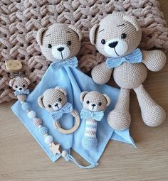 three crocheted teddy bears are sitting on the floor next to a blue blanket