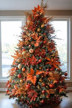 a decorated christmas tree in front of a window with orange and gold decorations on it