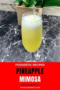 a pineapple mimosa cocktail in a tall glass on a marble countertop