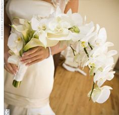 a bride holding a bouquet of white orchids